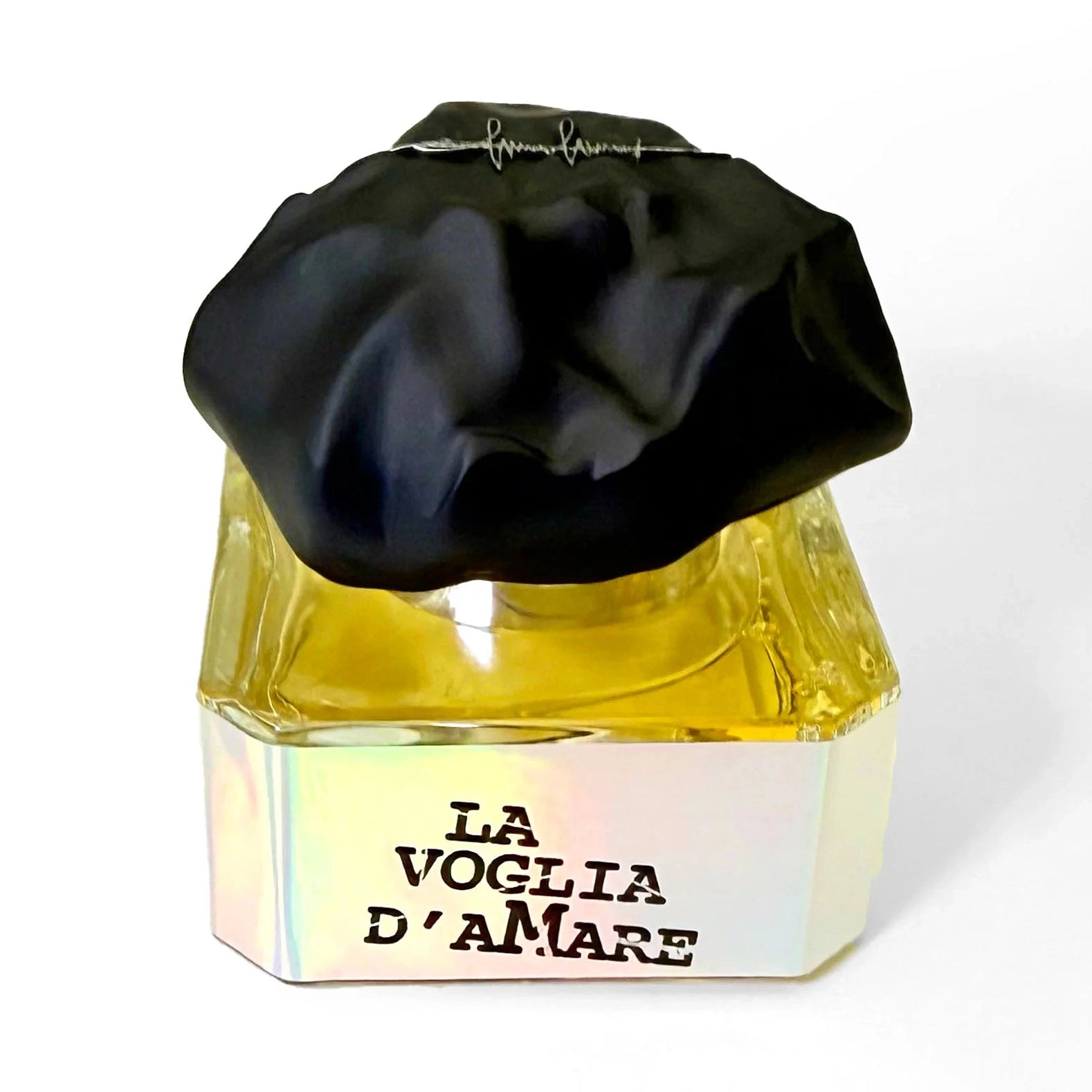 Close-up of Filippo Sorcinelli La Voglia D'Amare perfume bottle featuring faceted glass, golden-yellow liquid, and crumpled black fabric cap