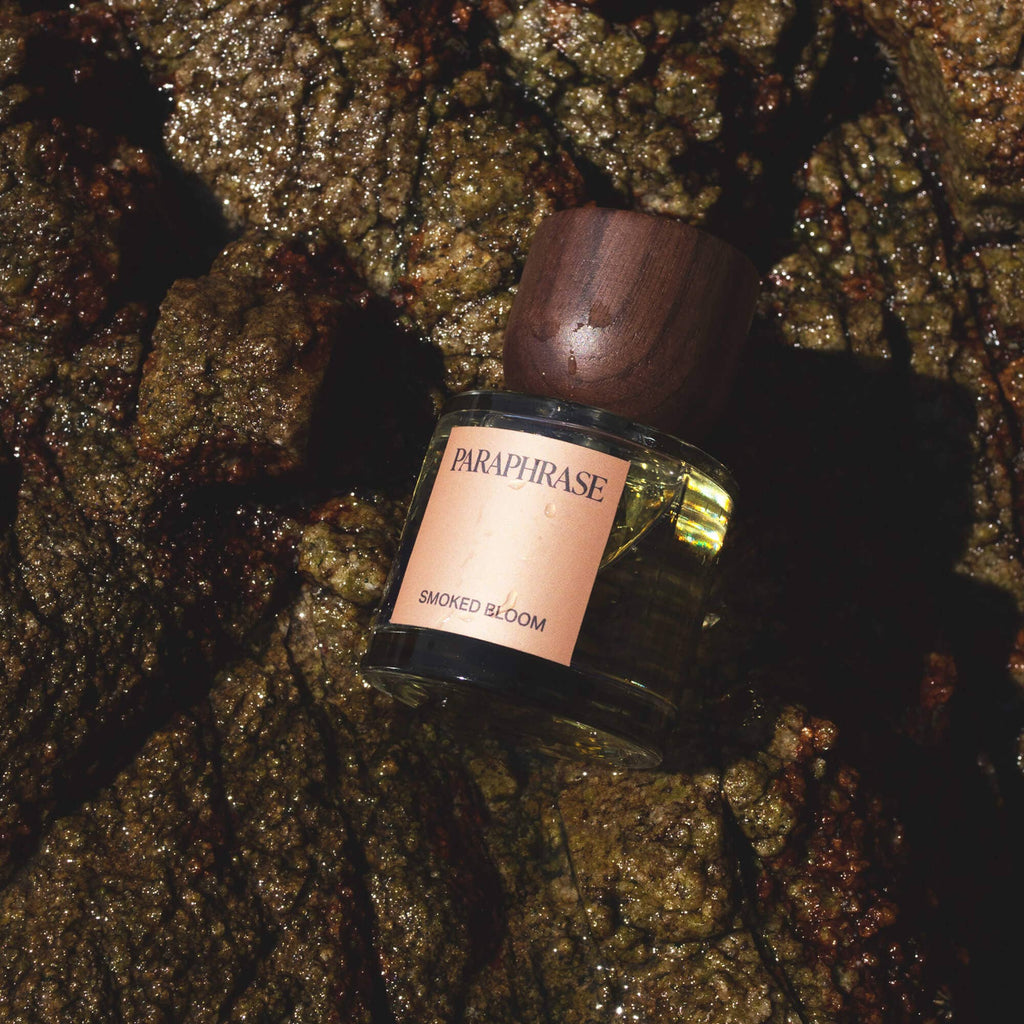 Paraphrase Smoked Bloom fragrance on wet textured rocks close-up