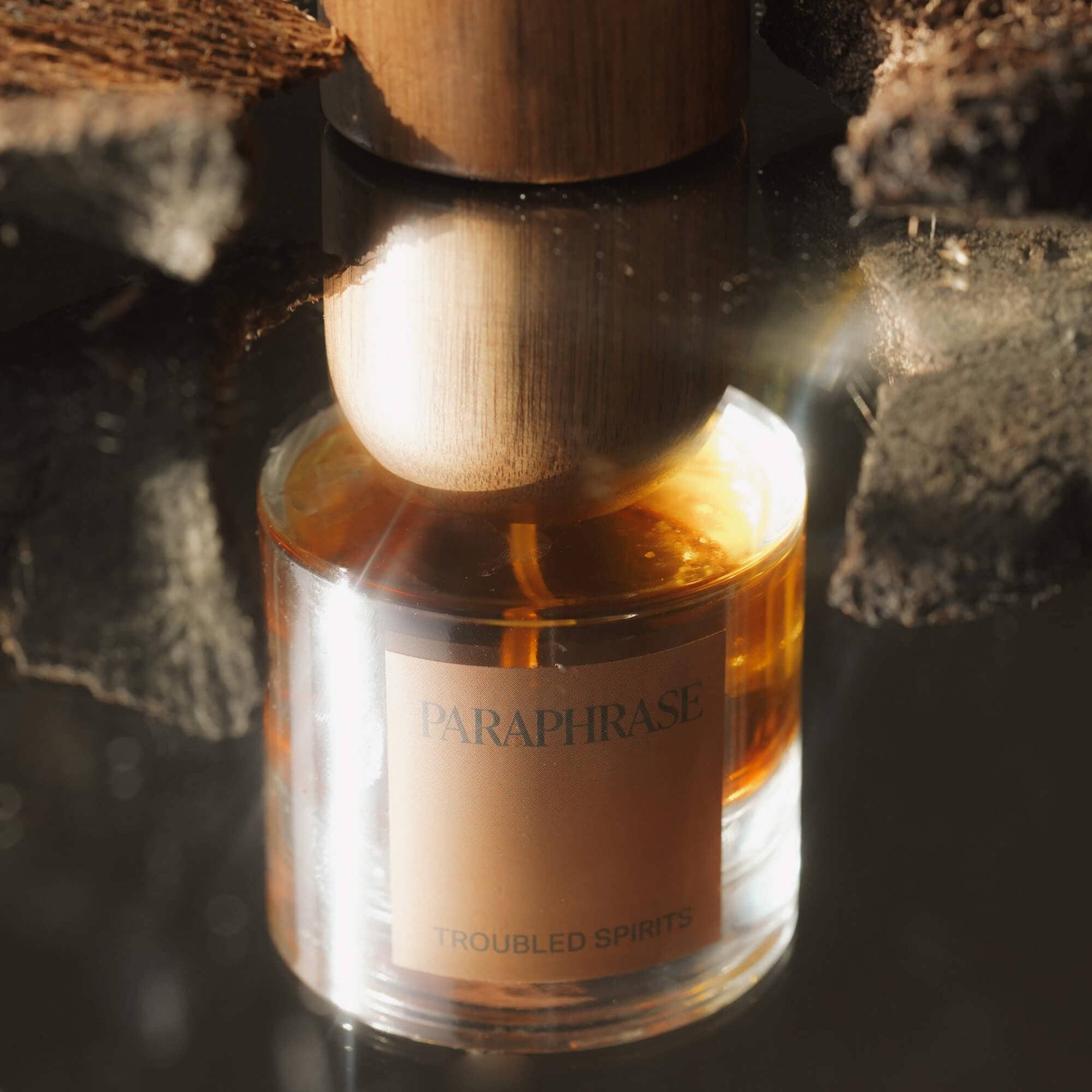 Paraphrase Troubled Spirits amber perfume bottle with wooden cap and organic texture