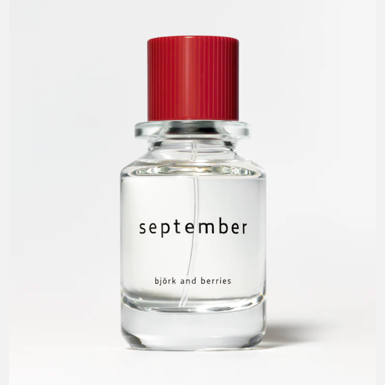 Bjork and Berries September Eau de Parfum in clear glass bottle with red ribbed cap