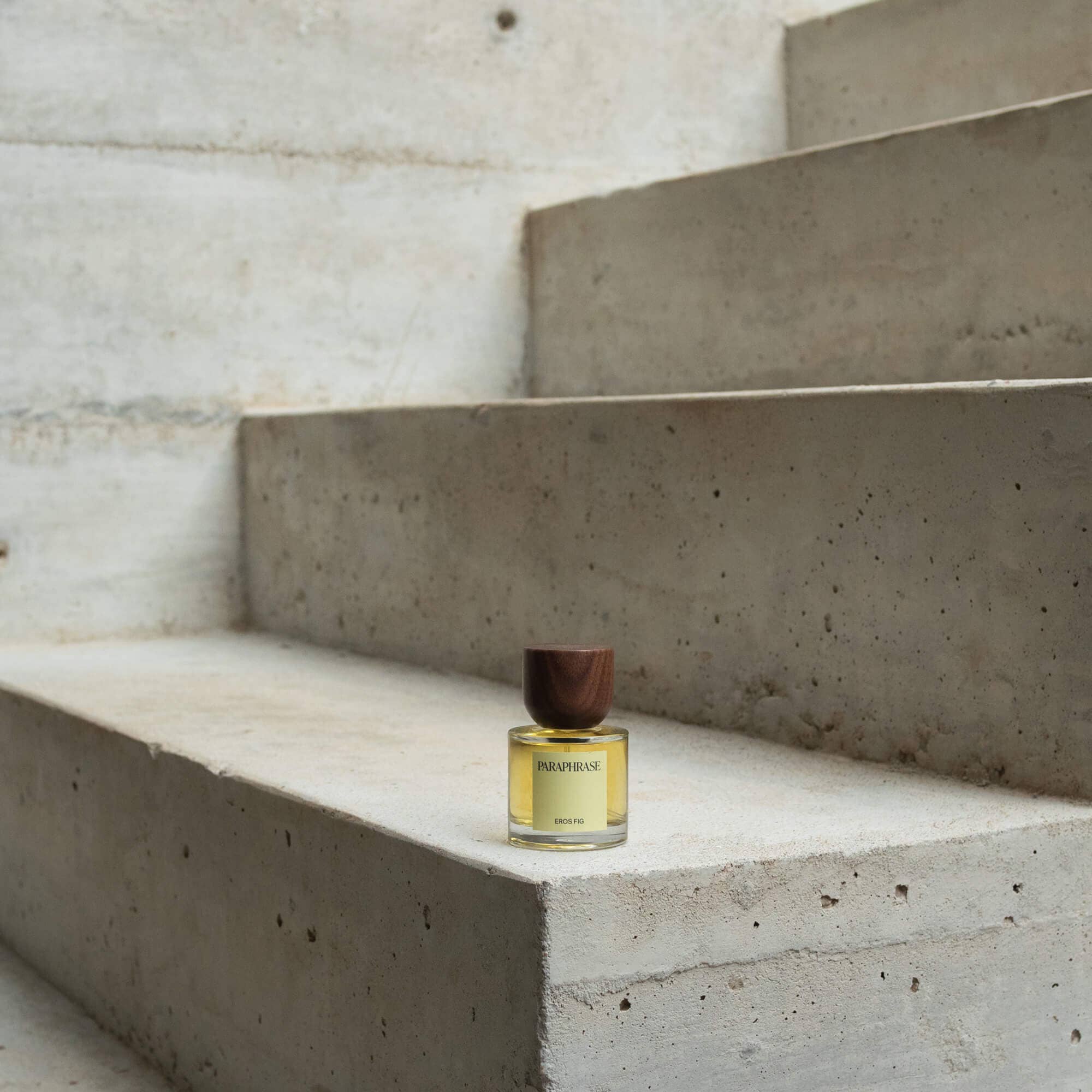 Paraphrase Eros Fig fragrance bottle on concrete step with wood cap