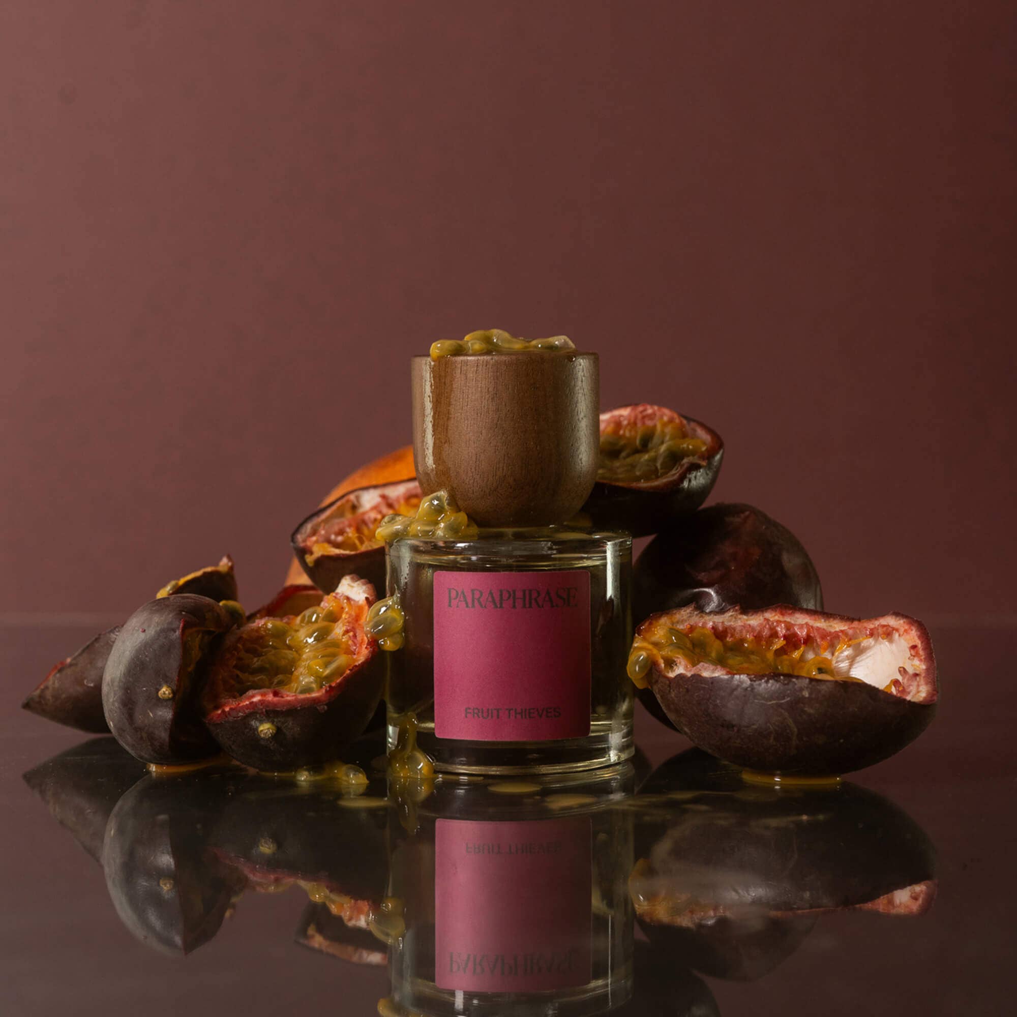 Fruit Thieves Eau de Parfum standing with halved passion fruits and dripping juice