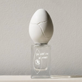 Perfume Who - the very eye of night. Egg-shaped bottle with a cracked top on a light gray background